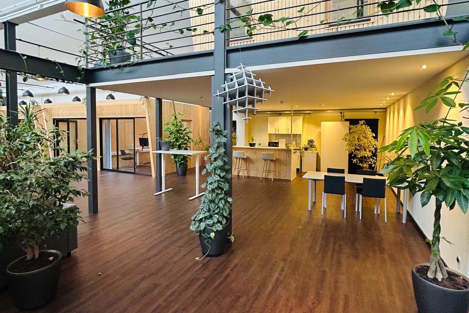 Gemeinschaftsküche im Green Office mit Tresen, Barhockern und Esstisch, darüber die Empore
