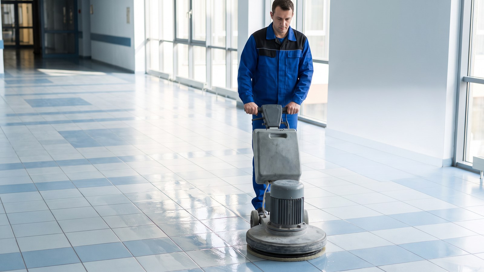 Mitarbeiter von GDE mit der Einscheibenmaschine auf einem frisch grundgereinigten, glänzenden Boden